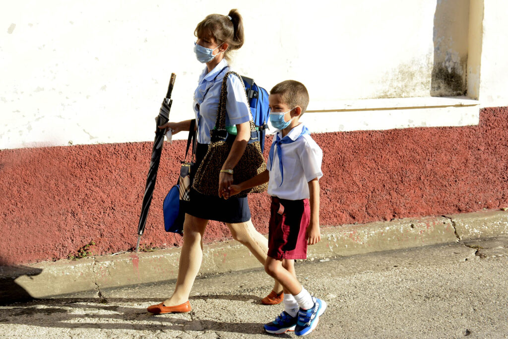 Madre con hijo rumbo a la escuela en el primer día de reinicio del curso escolar 2021-2022